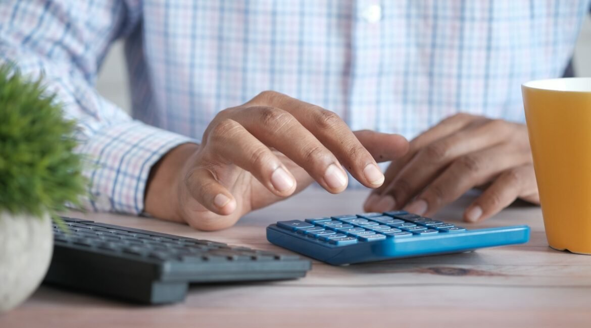 Pessoa usando calculadora sobre a mesa